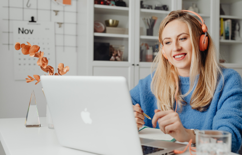 Woman wearing headphones looking at a laptop